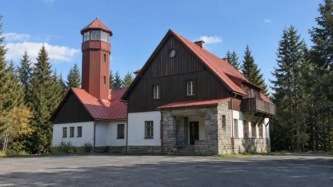 Horská chata Pancíř s osmibokou dřevěnou věží rozhledny mezi vysokými smrky